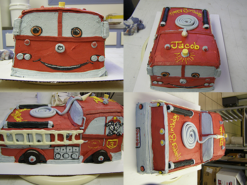 Custom firetruck-shaped novelty cake with red frosting and ladder details
