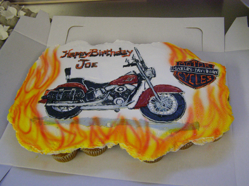 Detailed motorcycle-shaped novelty cake sculpted from cake and frosting