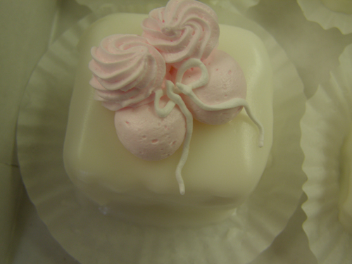 Elegant pink and white tiered cake with delicate rosette detailing