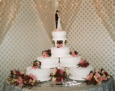 Pink-accented tiered wedding cake with delicate rose details by Lisa Becker's Bakery